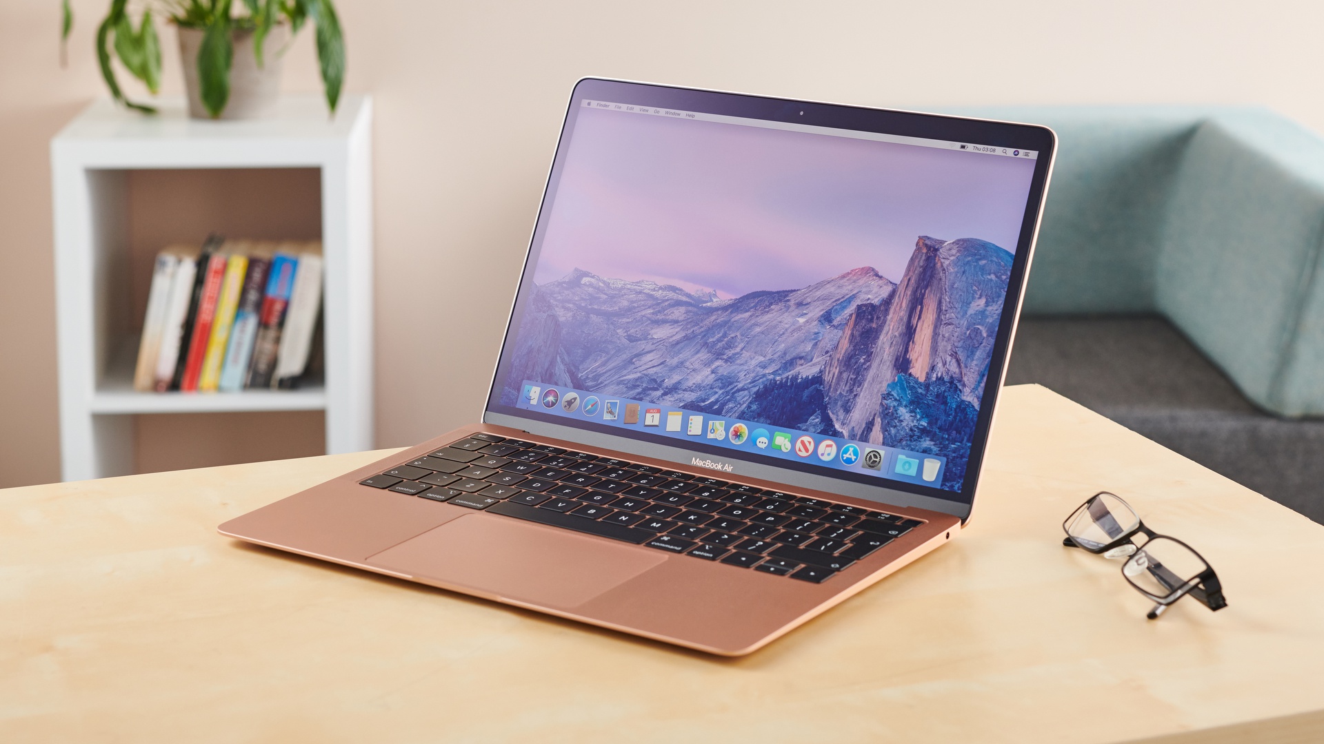 apple macbook air m1 review - an angled image of the rose gold macbook air m1 sitting on a wooden desk