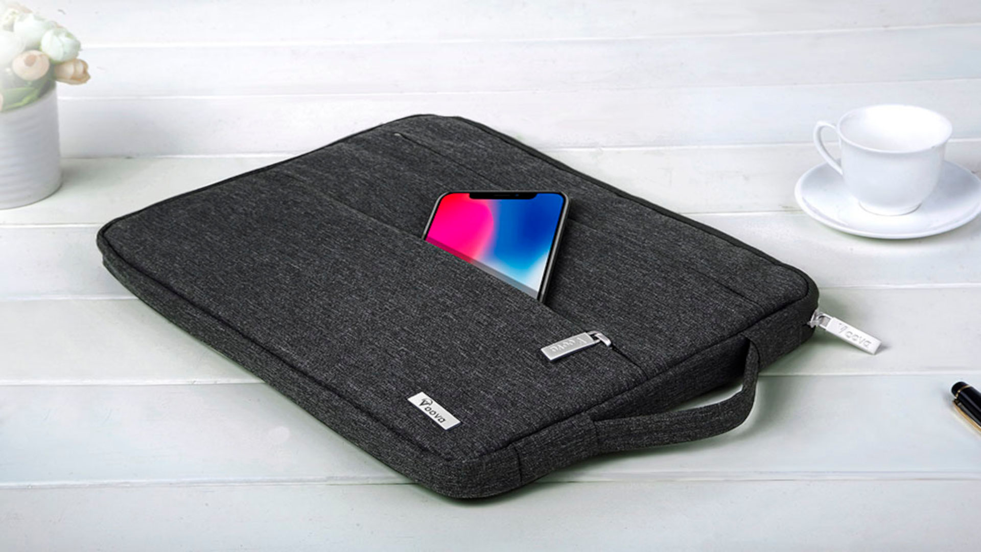 best laptop bags - an image of the voova laptop sleeve in slate grey with a phone peering out of the front storage pocket
